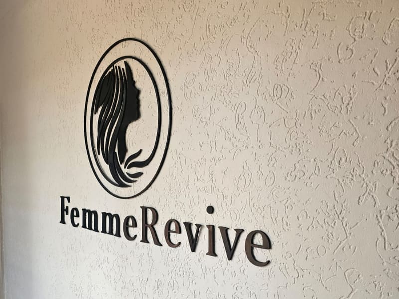 The FemmeRevive mark mounted on the studio wall